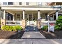 Inviting two-story house with a covered porch, manicured landscaping, and a for-sale sign at 1471 N Delaware St, Indianapolis, IN 46202