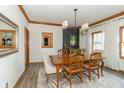 Elegant dining room features wood table, stylish lighting, and wood flooring, perfect for entertaining guests at 1622 E Mohr Rd, Greenfield, IN 46140