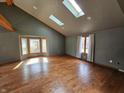 Bright living room featuring vaulted ceilings, skylights, and hardwood flooring at 16575 Audubon Ct, Noblesville, IN 46060
