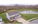 Aerial view of a two-story home with a pond, large yard, and three-car garage at 19477 Quilling Ln, Noblesville, IN 46062