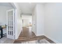 Bright hallway with wood floors and white trim, leading to an open living space at 19477 Quilling Ln, Noblesville, IN 46062