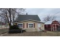 Back of the house featuring neutral siding, a door entrance, and a red storage shed at 2212 S Delawanda Ave, Muncie, IN 47302