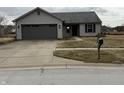 Charming single-story home with a well-manicured lawn and mature trees at 2418 Shorewood Dr, Lebanon, IN 46052