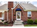 Close-up of a brick home's entrance showcasing the architectural details and manicured landscaping at 2615 Kessler Blvd E Dr, Indianapolis, IN 46220