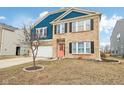 Inviting two-story home featuring brick and blue siding, a two-car garage, and a neatly landscaped front yard at 3132 W Meadowbend Dr, Monrovia, IN 46157