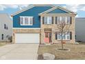 Inviting two-story home featuring brick and blue siding, a two-car garage, and a neatly landscaped front yard at 3132 W Meadowbend Dr, Monrovia, IN 46157