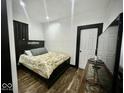 Cozy bedroom with a dark wood framed bed, light floral bedding, and wood grain floors at 318 Congress Ave, Indianapolis, IN 46208