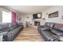 Comfortable living room with wood flooring, fireplace, and gray sofas at 323 Norris Dr, Anderson, IN 46013