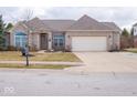 Charming brick home with a two-car garage, manicured flower beds, and covered entryway at 3791 Harveys Path, Greenwood, IN 46143