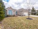 Charming single-story brick home featuring manicured flower beds and mature landscaping at 3791 Harveys Path, Greenwood, IN 46143