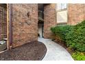 Brick townhouse entrance featuring a walkway, neatly landscaped yard, and door with unit number at 3840 Knollton Rd # A, Indianapolis, IN 46228