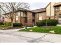 Brick townhouse features a walkway and a neatly landscaped front yard with mature trees and flowering shrubs at 3840 Knollton Rd # A, Indianapolis, IN 46228