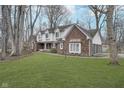 Beautiful two-story brick home with well-manicured lawn, mature trees, and an attached two-car garage at 5214 Woodfield Dr, Carmel, IN 46033