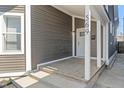 Inviting front porch with gray siding, white trim, and the house number displayed at 569 N Tacoma Ave, Indianapolis, IN 46201