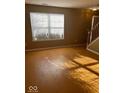 Inviting living room with large window allowing natural light and hardwood floors at 6030 Tybalt Cir, Indianapolis, IN 46254