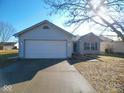 Single-story home featuring a two-car garage and well-maintained landscaping at 6221 Cradle River Dr, Indianapolis, IN 46221