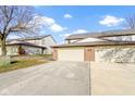 Attached two-car garage with brick facade and concrete driveway under a bright blue, partly cloudy sky at 6454 Bay Harbor Ln, Indianapolis, IN 46254