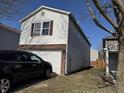 View of the side of a two story home with white siding and a brick accent around a garage door at 6647 Black Antler Cir, Indianapolis, IN 46217