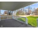 Relaxing covered patio with a spacious area for outdoor seating, perfect for enjoying the backyard view at 711 N Fenton Ave, Indianapolis, IN 46219