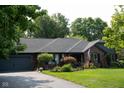 A single-story brick home with a well-manicured lawn, mature trees, and an attached two-car garage at 7971 Clearwater Ct, Indianapolis, IN 46256