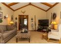 Cozy living room with vaulted ceilings, exposed beams, and comfortable seating at 7971 Clearwater Ct, Indianapolis, IN 46256