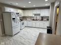Well-lit kitchen with white cabinets, modern appliances, and sleek tile flooring at 8960 Stepping Stone Way, Avon, IN 46123