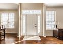 Bright foyer with hardwood floors, white door with sidelights, and natural light from two windows with blinds at 10628 Blackthorn Ct, Fishers, IN 46038