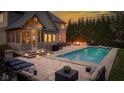 Luxurious backyard featuring a sparkling swimming pool, a cozy fire pit, and comfortable patio furniture at 10802 Giselle Way, Fishers, IN 46040