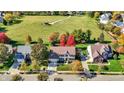 Overhead view of the home with colorful fall trees, lush green lawn, and proximity to a green common area at 12396 Dellfield W Blvd, Carmel, IN 46033