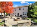Inviting backyard with a custom stone fire pit, patio, and mature trees providing privacy at 12396 Dellfield W Blvd, Carmel, IN 46033