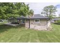 A stone-sided ranch-style home with a well-maintained yard and an open side lawn at 1459 S Josephine St, Martinsville, IN 46151