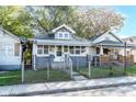 Inviting single-story house with a fenced front yard and classic architectural details at 2433 Indianapolis Ave, Indianapolis, IN 46208