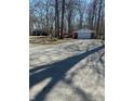 Exterior view of the home with a detached garage and gravel driveway at 28 Cambridge Ct, Anderson, IN 46012