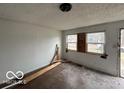 Sunlit living room with boarded windows, presenting an opportunity for renovation at 2912 N Gladstone Ave, Indianapolis, IN 46218