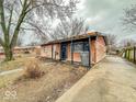View of the home's brick facade, covered porch, side driveway, and yard at 3423 N Sadlier Dr, Indianapolis, IN 46226