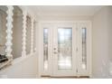 Elegant foyer showcases a decorative glass front door and staircase detail, enhancing the home's classic appeal at 3530 N County Road 950 E, Brownsburg, IN 46112