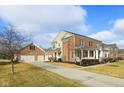 Expansive brick home with a three-car garage and lush landscaping, perfect for comfortable suburban living at 4604 S Cobblestone Dr, Zionsville, IN 46077