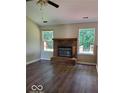 Living room features a red brick fireplace, hardwood floors, and natural light from two windows at 5822 Blackley Ln, Indianapolis, IN 46254