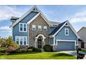 Charming two-story home with a brick facade, blue siding, and well-manicured lawn at 664 Hythe Way, Westfield, IN 46074