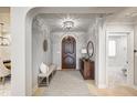 Elegant foyer with hardwood floors, a decorative rug, and a detailed wooden door at 6778 Old Hunt Club Rd, Zionsville, IN 46077