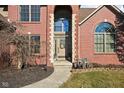The front door features an arched window and brick surround plus walkway and meticulous landscaping at 7619 Bluebird Ct, Brownsburg, IN 46112