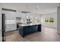 Modern kitchen boasts white cabinets, stainless steel appliances, a large island, and ample counter space at 7707 Walker Dr, Avon, IN 46123