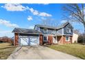 Charming two-story home boasts a brick and siding exterior with an attached two car garage at 7929 Castle Lake Rd, Indianapolis, IN 46256