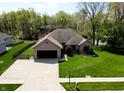 Well-maintained home with a brick facade, attached garage, and a large driveway at 7987 Teal Dr, Coatesville, IN 46121