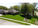 Manicured front lawn with lush green grass and mature trees framing the house at 7987 Teal Dr, Coatesville, IN 46121