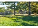 Spacious property featuring green home, garage, and expansive lawn with mature trees at 8090 E 550 S, Zionsville, IN 46077