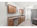 Well-lit kitchen with wood cabinets, stainless steel dishwasher and sink, providing a practical cooking space at 827 N Tacoma Ave, Indianapolis, IN 46201
