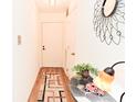 Hallway with wood flooring, decorative mirror and runner, illuminated by a table lamp at 8830 Yardley Ct # 103, Indianapolis, IN 46268