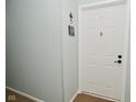 View of condo entry door, number 103, with neutral paint and carpeted floors at 8830 Yardley Ct # 103, Indianapolis, IN 46268