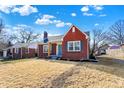 Charming brick home with a well-manicured lawn, blue sky, and mature trees at 910 N Downey Ave, Indianapolis, IN 46219